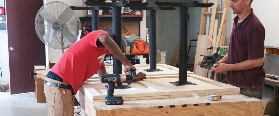 Workers construct café tables from reclaimed materials at L!VE Café in Chicago, Illinois.