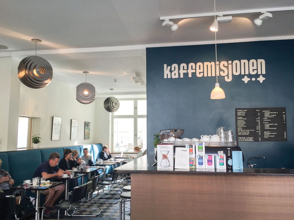 The blue walls and decorative light fixtures inside Bergen's Kaffemisjonen; Bergen coffee.