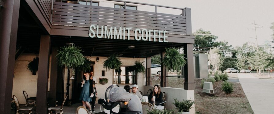 An outside photo of Summit Coffee, a coffee shop with people sitting around.